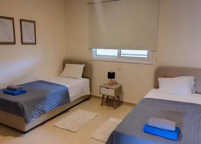 a bedroom with two beds and a window at Mythical Sands Luxury Apartment in Paralimni