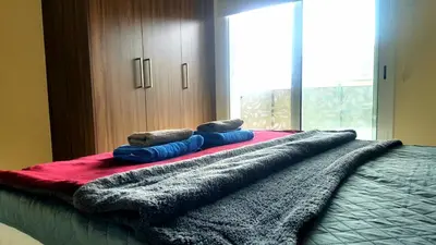 a bed with three pillows on top of it at Mythical Sands Luxury Apartment in Paralimni