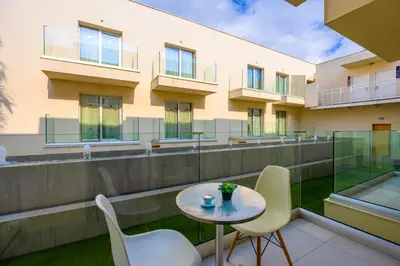 a balcony with a table and chairs and a building at Melpo Antia Hotel & Suites in Ayia Napa