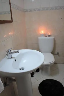 a bathroom with a sink and a toilet and candles at Salt Lake Town House in Larnaka