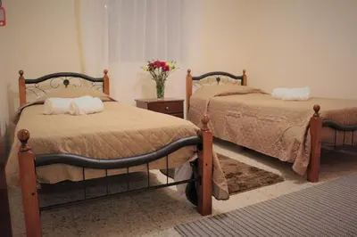 a bedroom with two beds and a vase of flowers at Salt Lake Town House in Larnaka