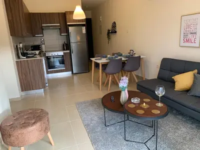 a living room with a couch and a table at Mythical Sands new Luxury Apartment in Paralimni
