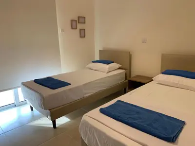 a bedroom with two beds and a window at Mythical Sands new Luxury Apartment in Paralimni