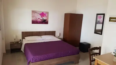 a bedroom with a bed with a purple blanket at ZORBAS Sea View No 1 - Antoniella in Larnaka
