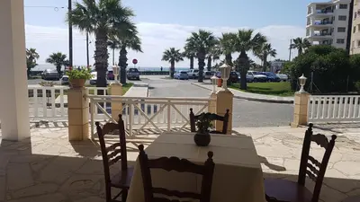 a table and chairs in front of a white fence at ZORBAS Sea View No 1 - Antoniella in Larnaka