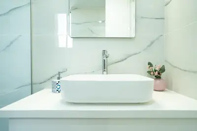 a bathroom with a white sink and a mirror at Andreotis Villas in Protaras