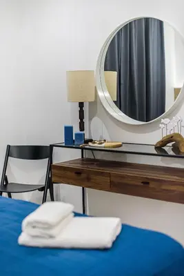a mirror sitting on top of a desk next to a bed at Andreotis Villas in Protaras