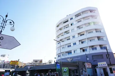 a large white building in front of a street at Lazuli Sea View Beachfront- Ap 61 in Larnaka