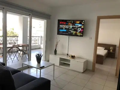 a living room with a couch and a tv on the wall at Must Stay - City Center in Larnaka