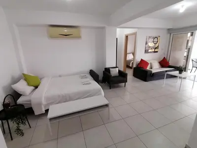 a bedroom with a bed and a living room at Must Stay - City Center in Larnaka