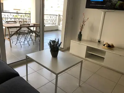 a living room with a white table and a living room at Must Stay - City Center in Larnaka