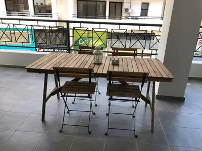 a wooden table with four chairs in a room at Must Stay - City Center in Larnaka