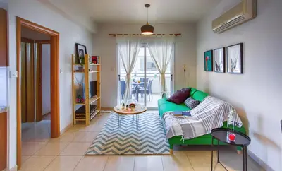 a living room with a green couch in a room at Yippee! Apartments I Town Center in Larnaka