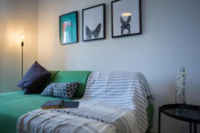 a bedroom with a green bed with books on it at Yippee! Apartments I Town Center in Larnaka