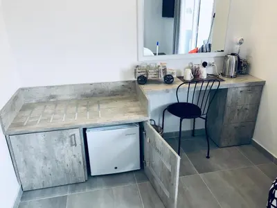 a kitchen with a counter and a table and a chair at White 11 in Larnaka