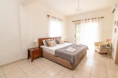 a bedroom with a bed and a couch in it at Konnos Villa Ekaterina in Protaras