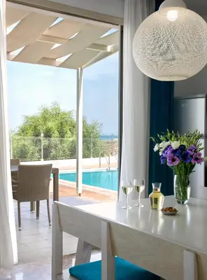 a dining room with a table with wine glasses at Althea Kalamies Luxury Villas in Protaras
