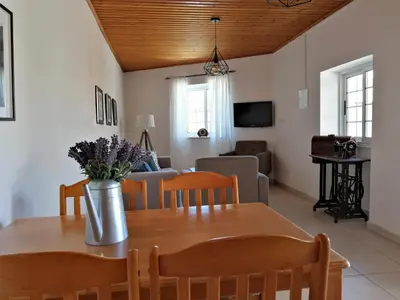 a dining room and living room with a table and chairs at Lemon Tree Courtyard in Larnaka