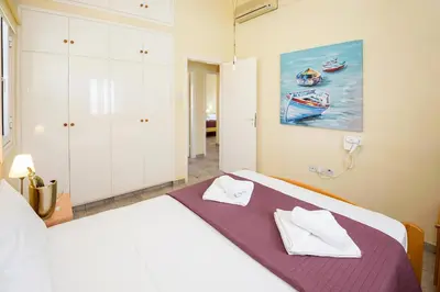 a bedroom with a bed and a painting of boats at Villa Aleta in Protaras