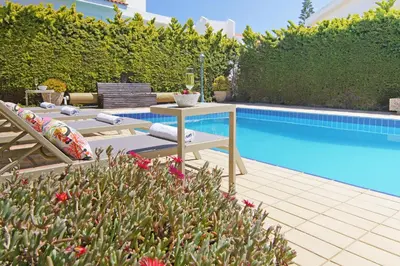 a swimming pool with a table and chairs next to a patio at Villa Aleta in Protaras