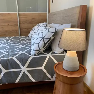 a bedroom with a bed with a lamp on a table at Modern 2 bed room large apartment in Nicosia