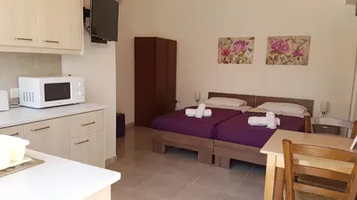 a bedroom with a bed and a kitchen with a microwave at ZORBAS No 3 in Larnaka