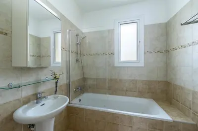 a bathroom with a bath tub and a sink at Kalimera Villa Protaras in Protaras