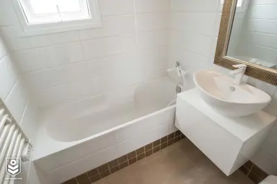 a white bathroom with a sink and a bath tub at Aquamarine in Voroklini