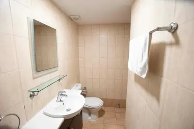 a bathroom with a sink and a toilet and a mirror at Glabur Stays - The Cozy Atelier - Nicosia City, Free Parking & Wifi, Welcomes You!!! in Nicosia