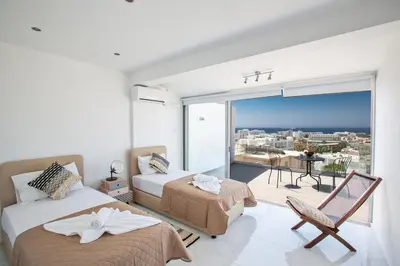 a bedroom with two beds and a view of a city at Rio Luxury Apartment in Ayia Napa