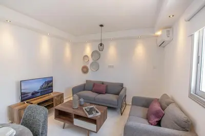 a living room with two couches and a tv at Rio Luxury Apartment in Ayia Napa