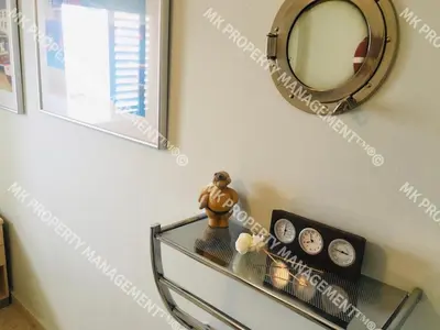 a shelf with clocks and a mirror on a wall at Yiallos Village C107 in Larnaka