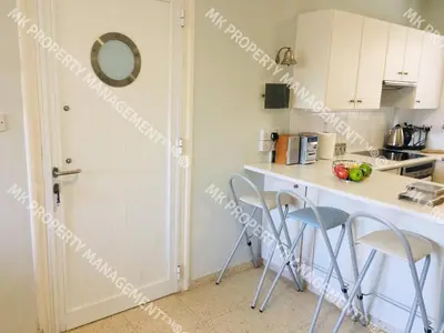a kitchen with a counter and stools in a room at Yiallos Village C107 in Larnaka