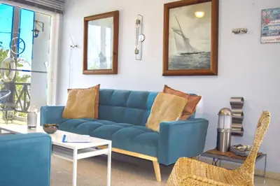 a living room with a blue couch and a table at Yiallos Village C107 in Larnaka