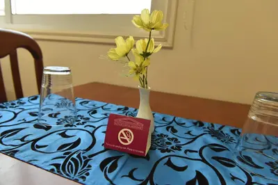 a vase with yellow flowers in it on a table at Elysium Capital Residence in Nicosia