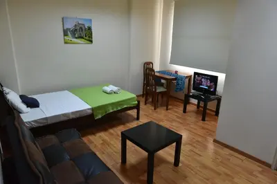 a room with a bed and a table and a tv at Elysium Capital Residence in Nicosia