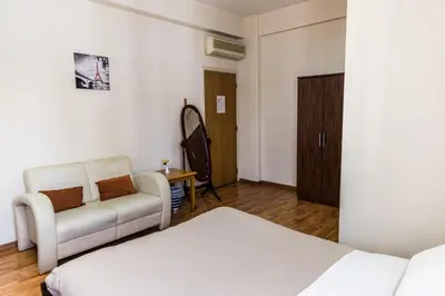 a room with a bed and a couch and a table at Elysium Capital Residence in Nicosia