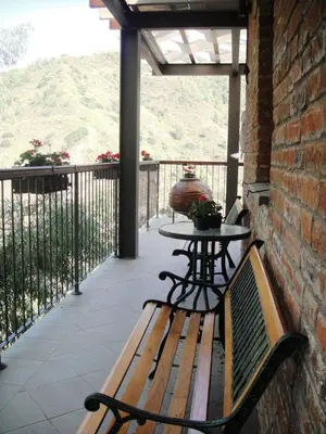 a wooden bench sitting on a porch with a table at Archontiko I Misirlou in Kalopanayiotis