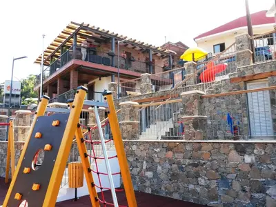 a playground in front of a building with a slide at Archontiko I Misirlou in Kalopanayiotis
