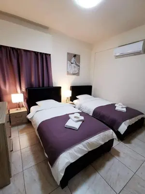 a bedroom with two beds with towels on them at Tony’s Boutique Apartment in Larnaka