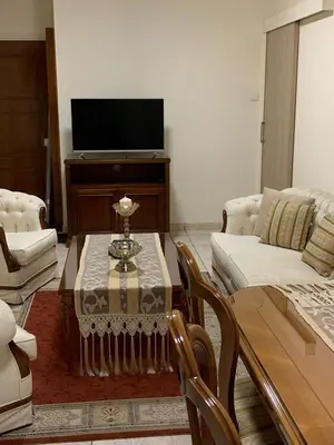 a living room with a table and a tv at Tony’s Boutique Apartment in Larnaka
