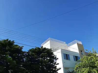 a white building with trees in front of it at Limassol sea view studio in Limassol