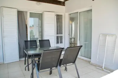 a dining room with a table and chairs on a balcony at Yiallos Village Apt. A101 in Meneou