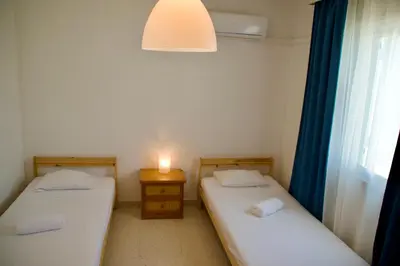two twin beds in a room with a window at Yiallos Village Apt. A101 in Meneou
