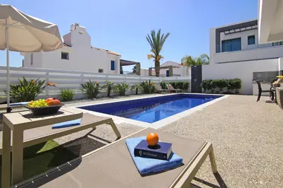 a backyard with a pool and a table with a bowl of fruit at Villa Megan in Protaras