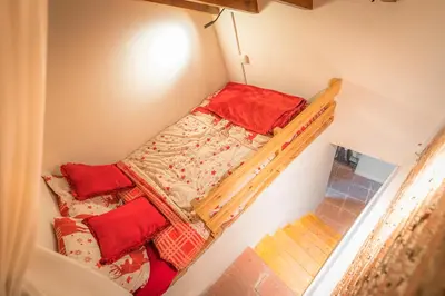 a small room with a bunk bed with red pillows at Madari Hills Health Retreat in Nicosia