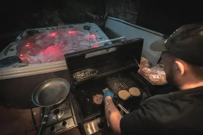 a man is cooking food on an outdoor grill at Madari Hills Health Retreat in Nicosia