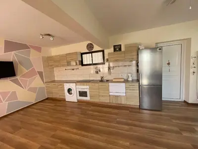 a large kitchen with a stainless steel refrigerator at 1bd next to Dasudi in Limassol