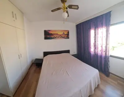 a bedroom with a white bed and a ceiling fan at 1bd next to Dasudi in Limassol
