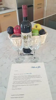 a bottle of wine and two wine glasses on a counter at Villa Di Gio in Paralimni